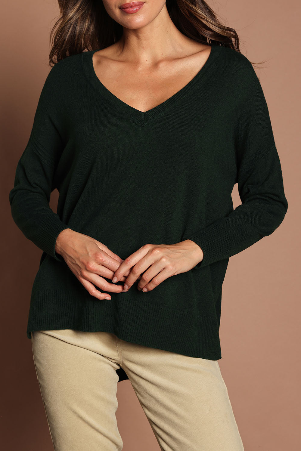 Model Madeline wearing size S of The High Low V Neck Jumper in colour Forest (Green), from the front, cropped image