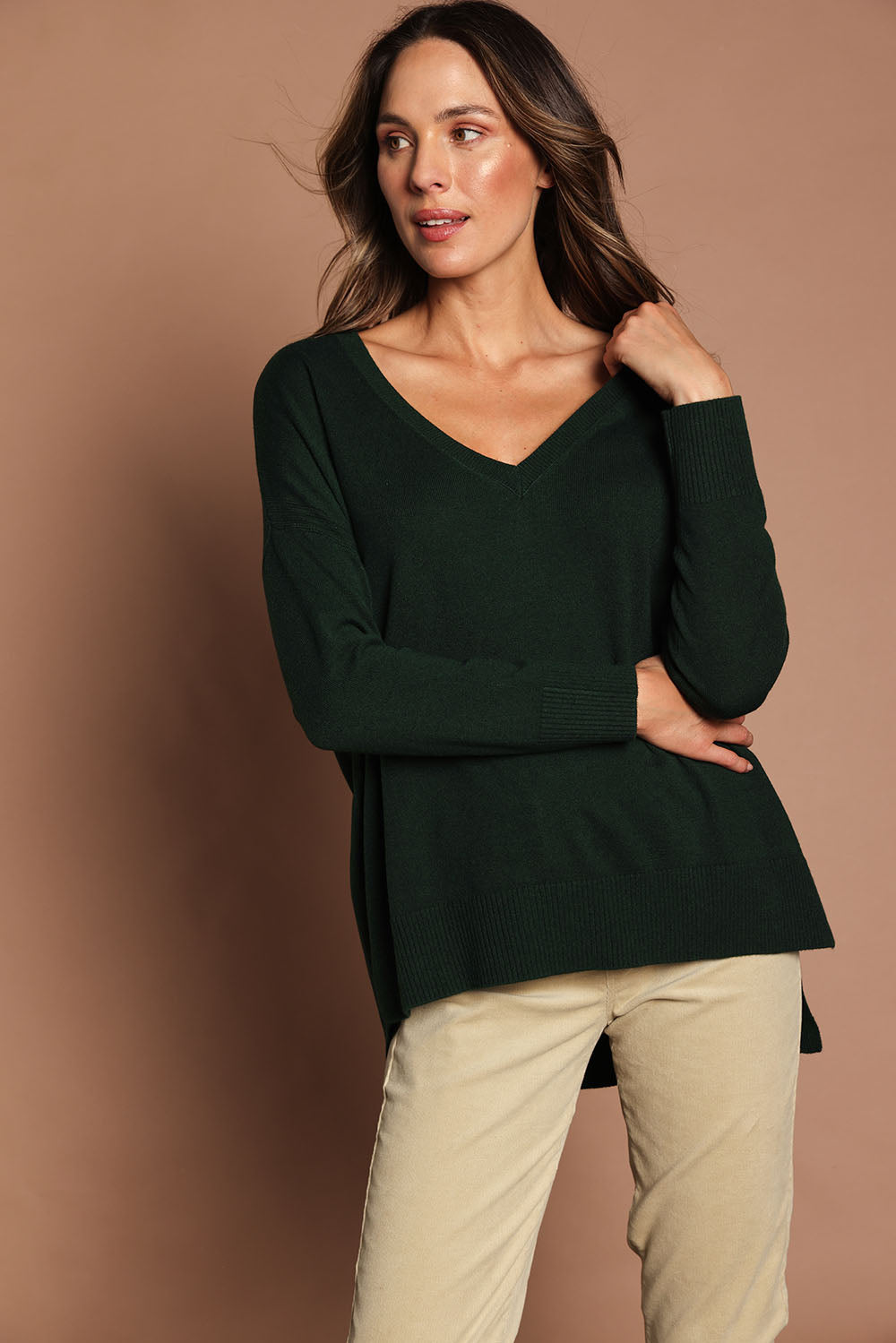 Model Madeline wearing size S of The High Low V Neck Jumper in colour Forest (Green), from the front, showing the whole outfit