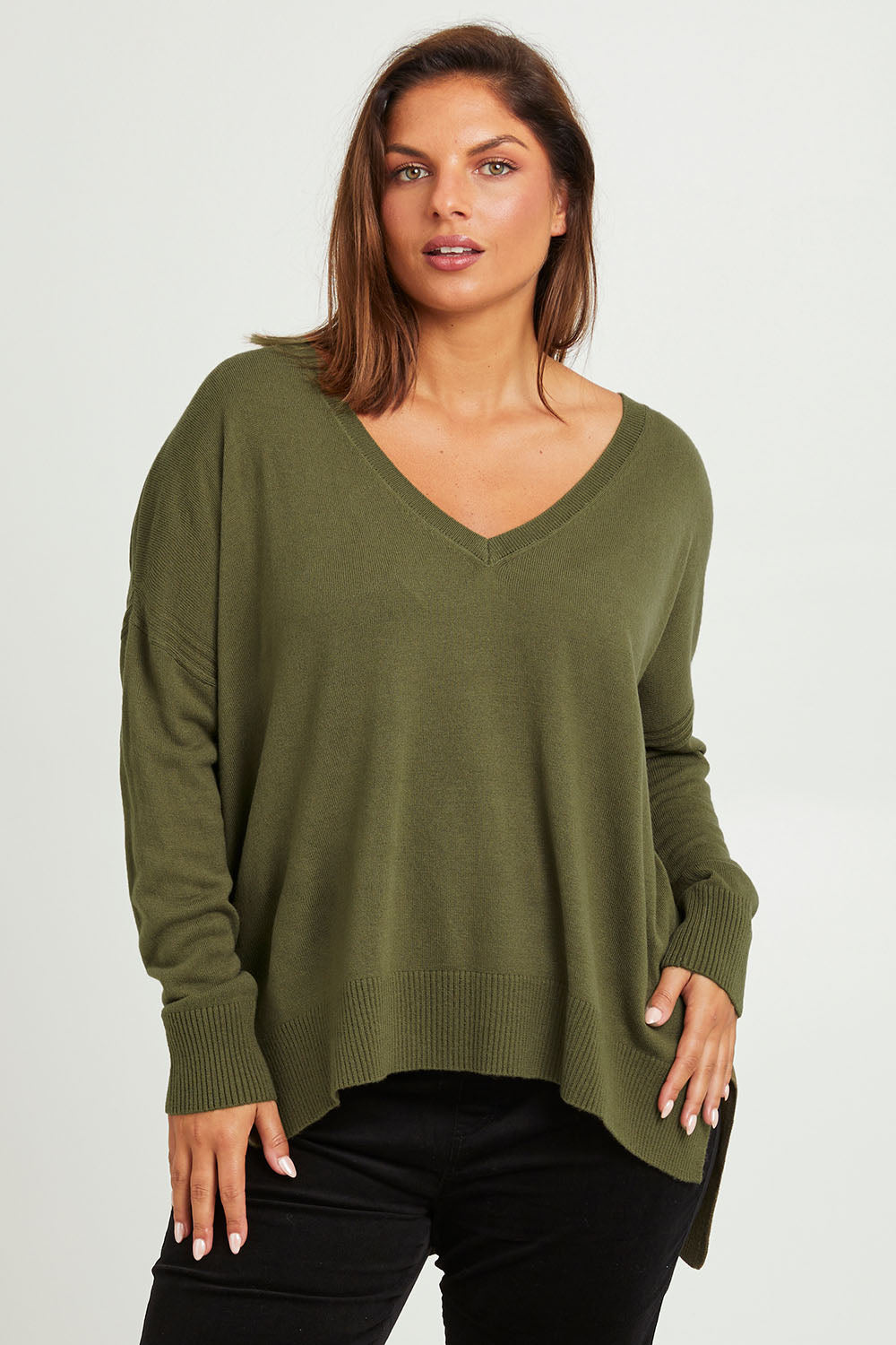 Model Monique wearing size L of The High Low V Neck Jumper in colour Khaki (Green), from the front, cropped image
