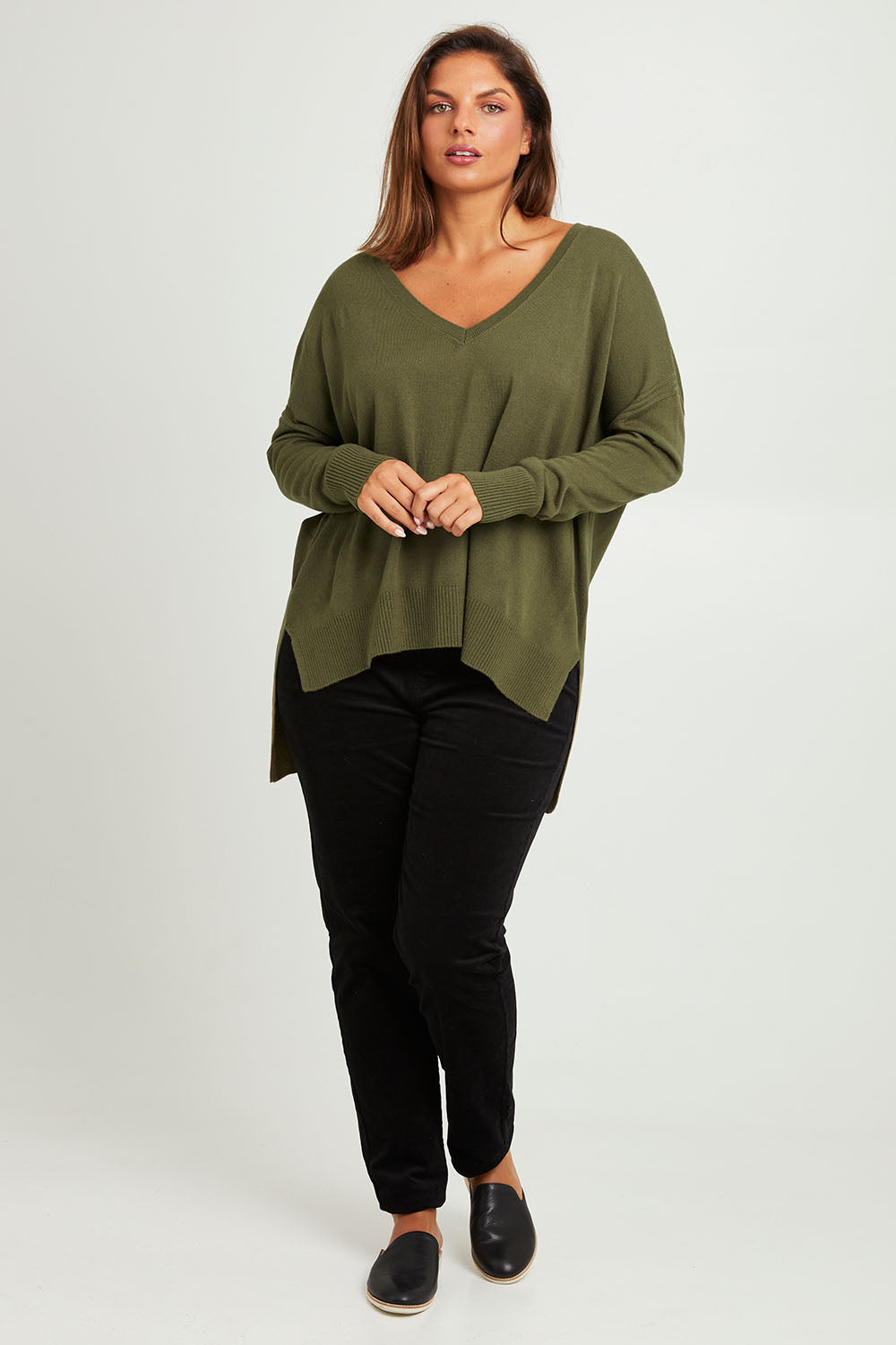 Model Monique wearing size L of The High Low V Neck Jumper in colour Khaki (Green), from the front, showing the whole outfit
