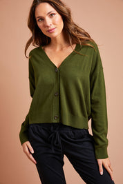 Model Madeline wearing size S of The Soft Cropped Cardigan in colour Darkolive (Green), from the front, showing the whole outfit
