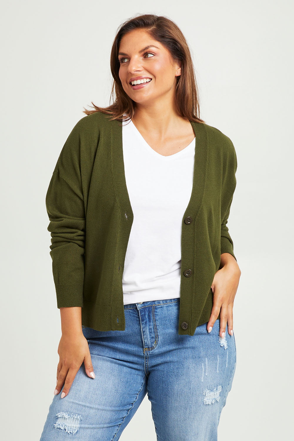 Model Monique wearing size L of The Soft Cropped Cardigan in colour Darkolive (Green), from the front, cropped image