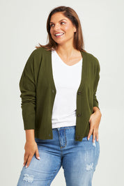 Model Monique wearing size L of The Soft Cropped Cardigan in colour Darkolive (Green), from the front, cropped image