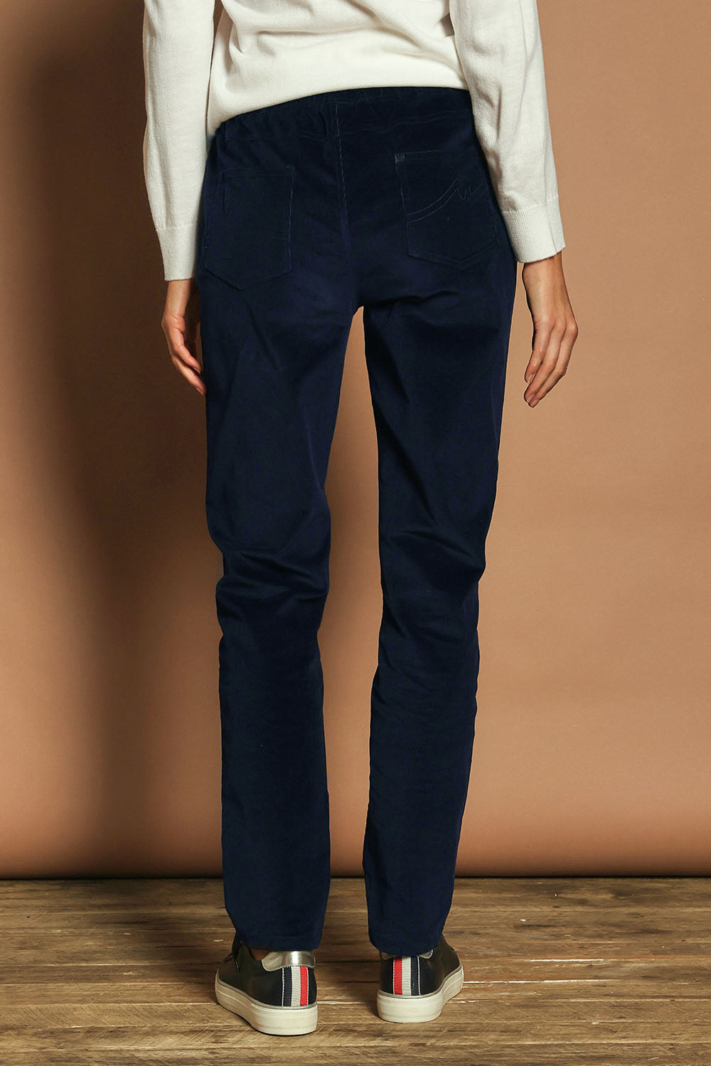 Model Madeline wearing size 10 of The Keepers Cord Pull On Pant in colour Darknavy (Blue), from the back