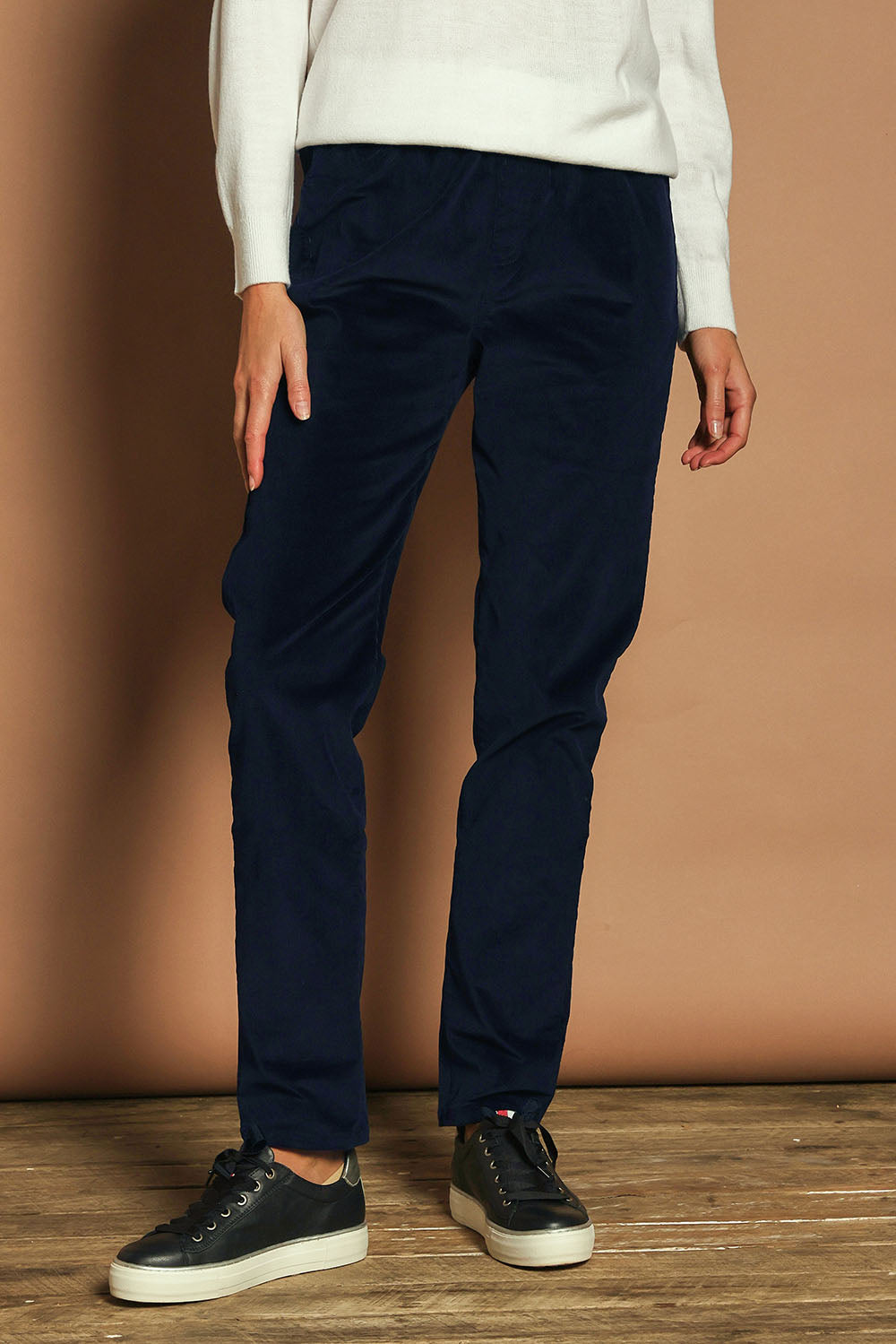 Model Madeline wearing size 10 of The Keepers Cord Pull On Pant in colour Darknavy (Blue), from the front, cropped image