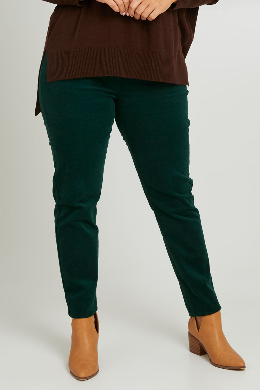 Model Monique wearing size 14 of The Keepers Cord Pull On Pant in colour Forest (Green), from the front, cropped image