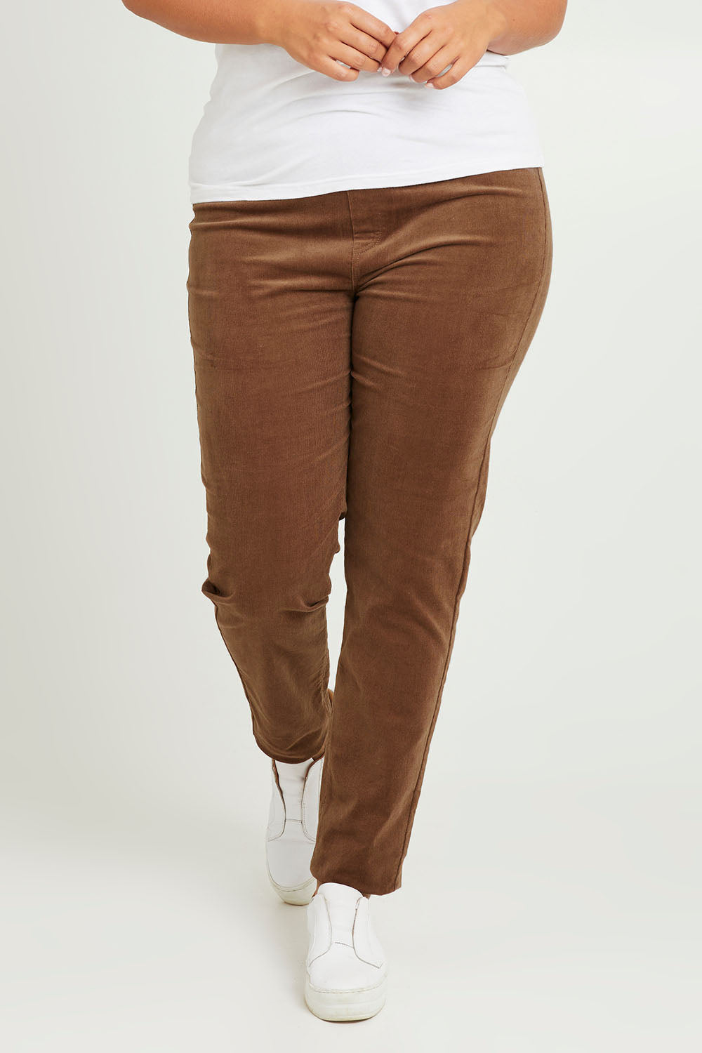 Model Monique wearing size 14 of The Keepers Cord Pull On Pant in colour Mushroom, from the front, cropped image