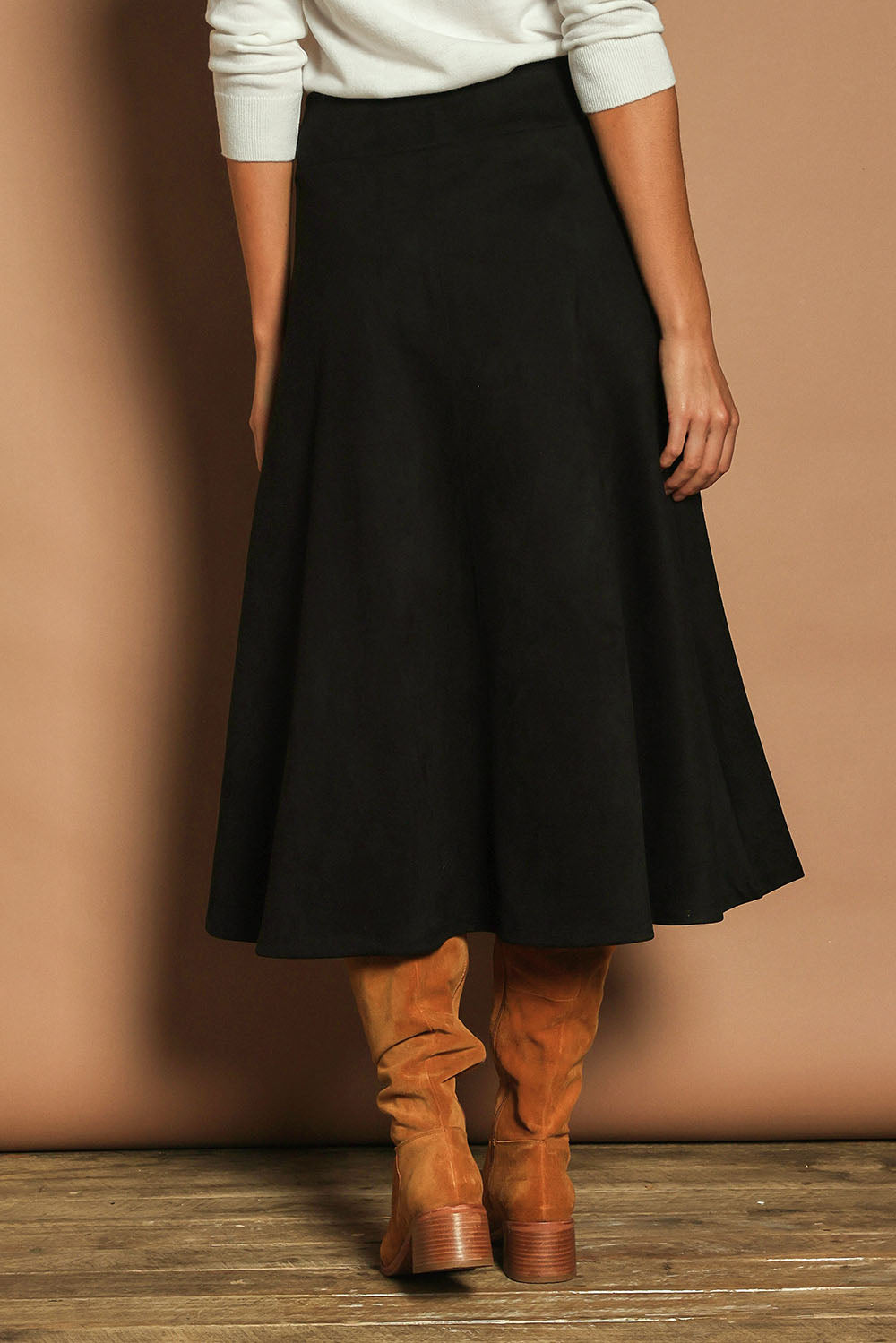 Model Madeline wearing size 10 of The Luxe Faux Suede Skirt in colour Black (Black), from the back