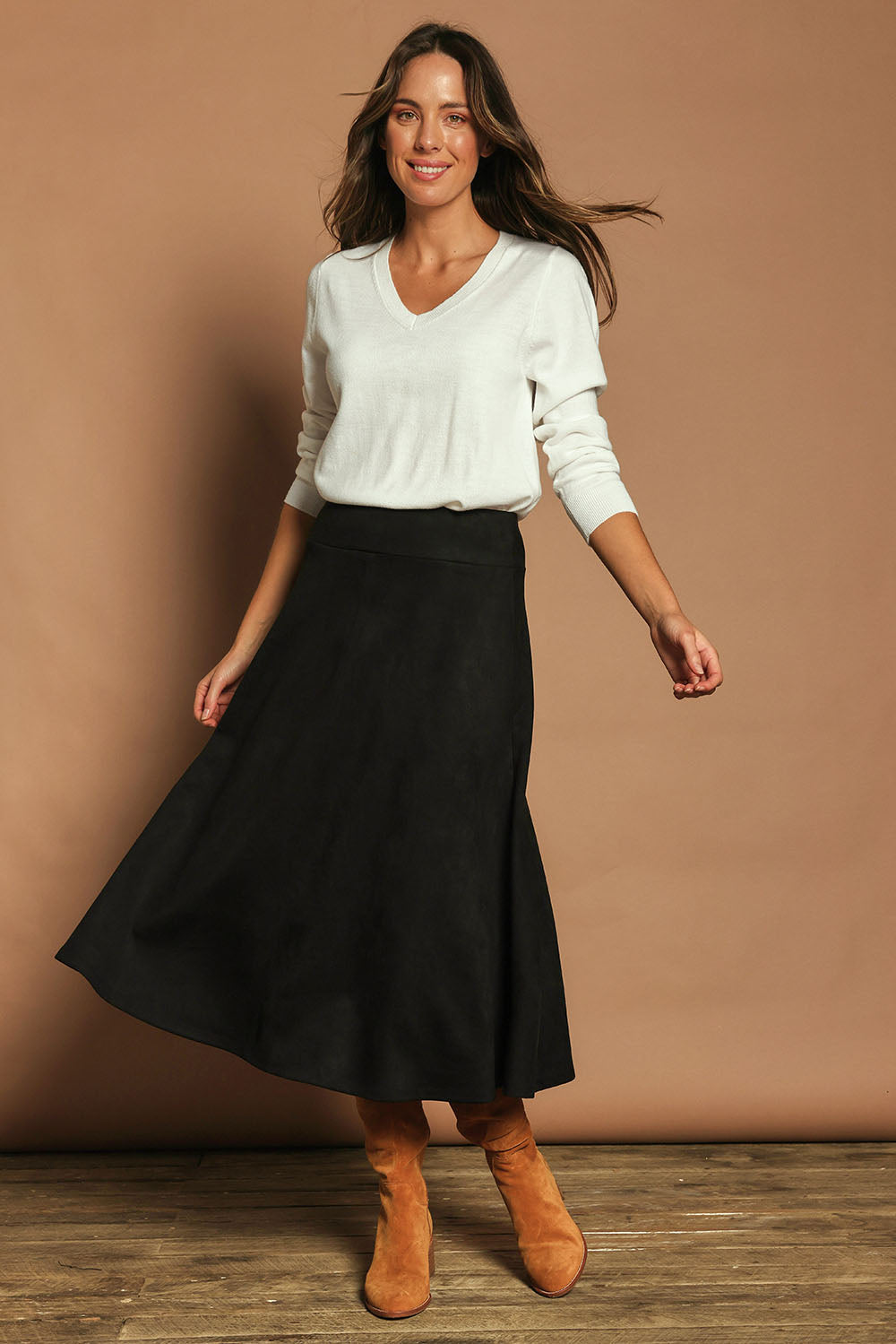 Model Madeline wearing size 10 of The Luxe Faux Suede Skirt in colour Black (Black), from the front, showing the whole outfit