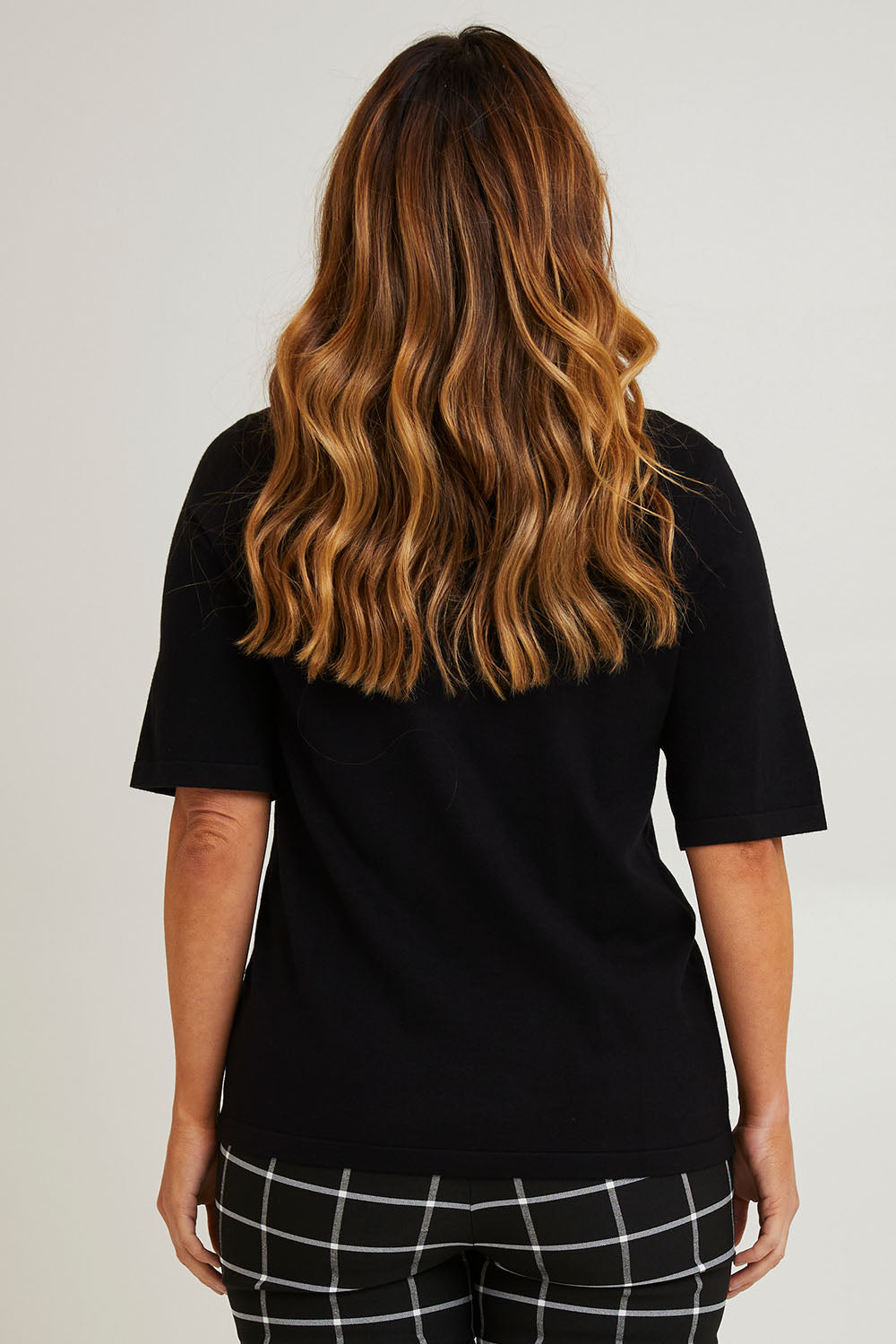 Model Laura wearing size L of The All Season Crew Neck Knit Tee in colour Black (Black), from the back