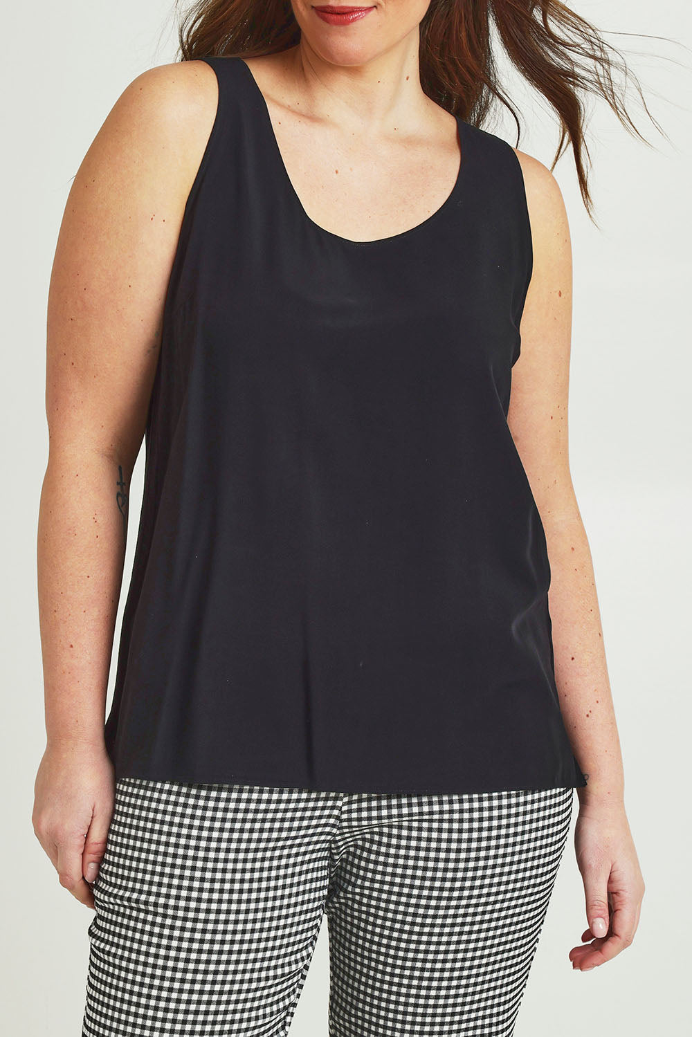 Model Jane wearing size 14 of The Keepers Essential Woven Tank in colour Black (Black), from the front, cropped image