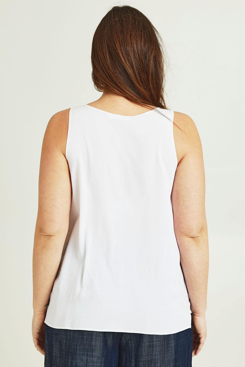Model Jane wearing size 14 of The Keepers Essential Woven Tank in colour White (White), from the back