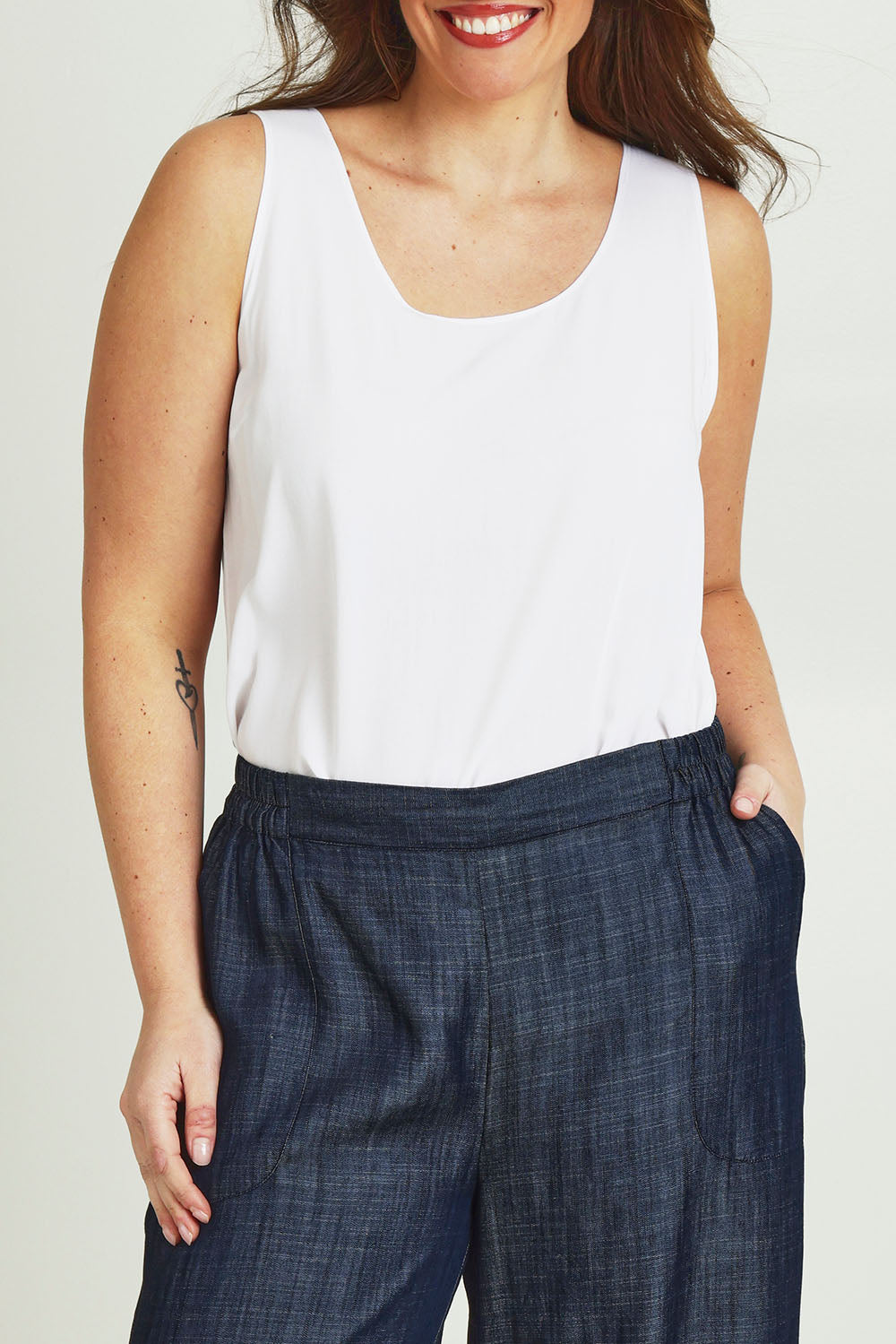 Model Jane wearing size 14 of The Keepers Essential Woven Tank in colour White (White), from the front, cropped image