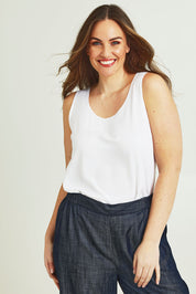 Model Jane wearing size 14 of The Keepers Essential Woven Tank in colour White (White), from the front, cropped image