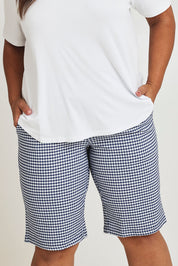 Model Ashleigh wearing size 16 of The Keepers Check Cotton Short in colour Navywhite (Blue), from the front, cropped image