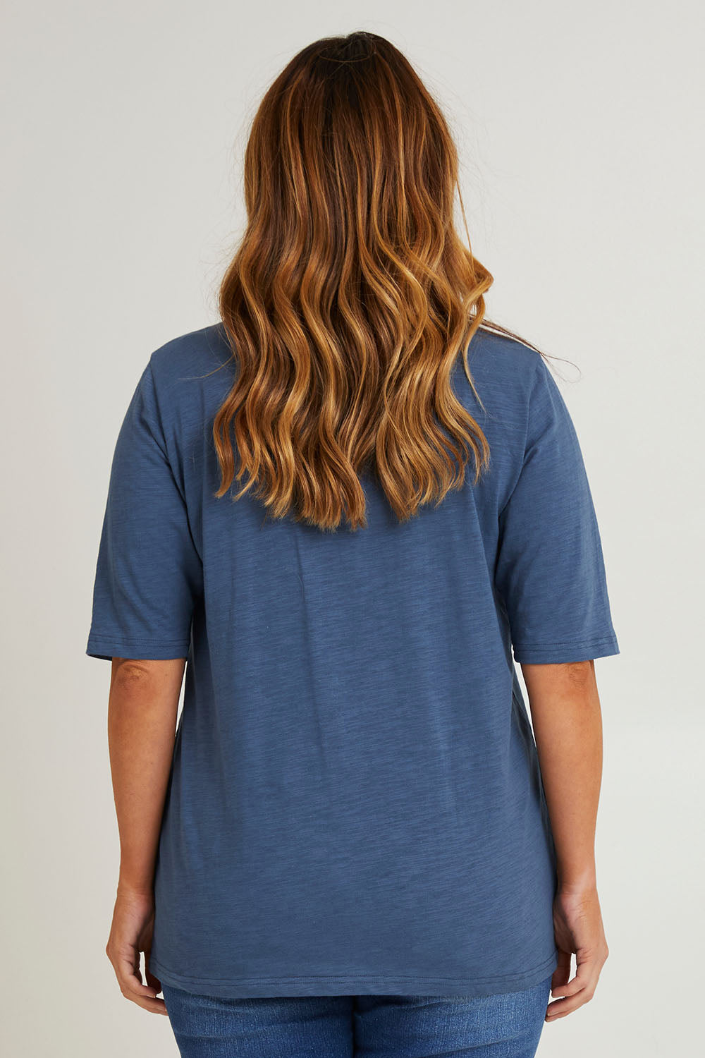 Model Laura wearing size 14 of The Cotton Slub Tunic in colour Denim (Blue), from the back