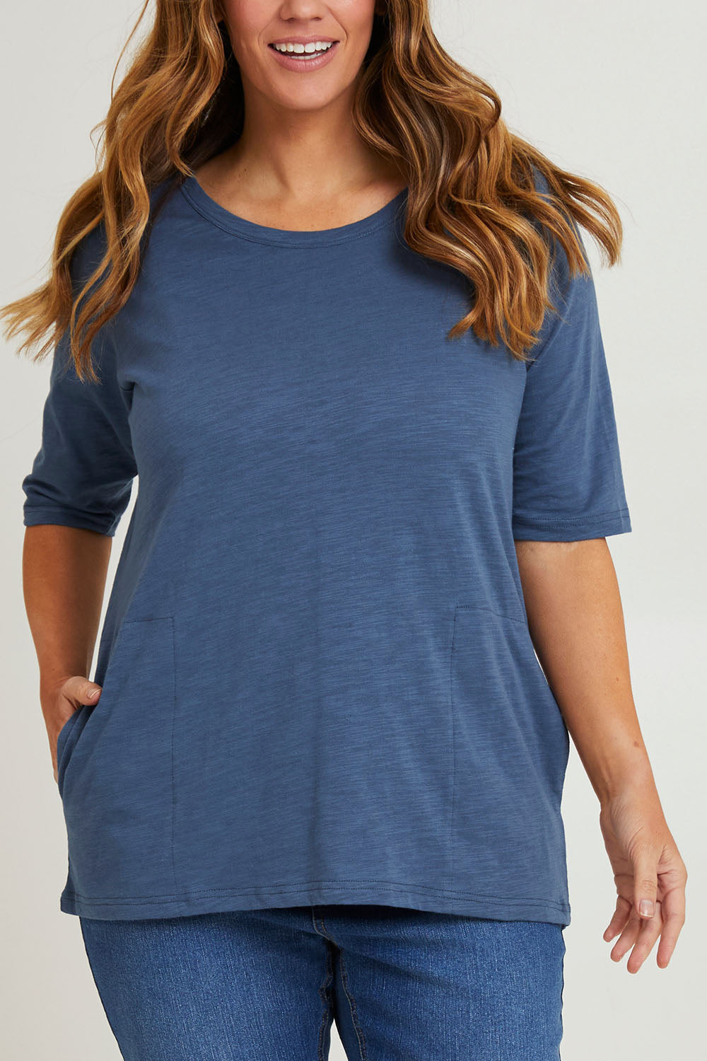 Model Laura wearing size 14 of The Cotton Slub Tunic in colour Denim (Blue), from the front, cropped image