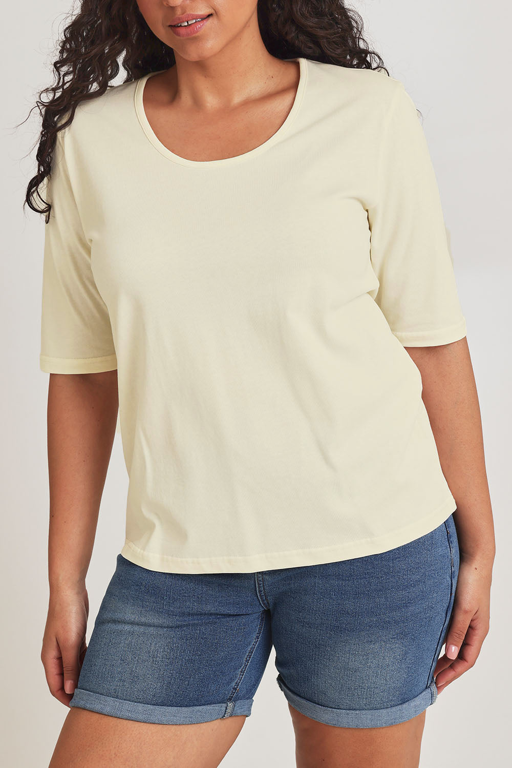 Model Terri-Leigh wearing size 14 of The Luxe Pima Cotton Tee in colour Lemon, from the front, cropped image