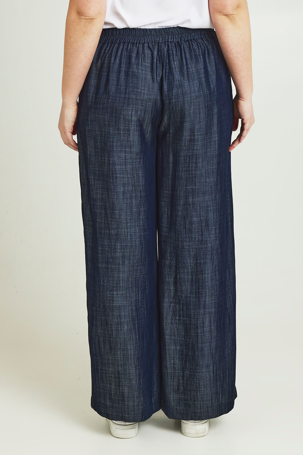 Model Jane wearing size 14 of The Luxe Chambray Pull On Pant in colour Darkdenim (Blue), from the back