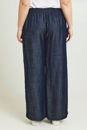 Model Jane wearing size 14 of The Luxe Chambray Pull On Pant in colour Darkdenim (Blue), from the back