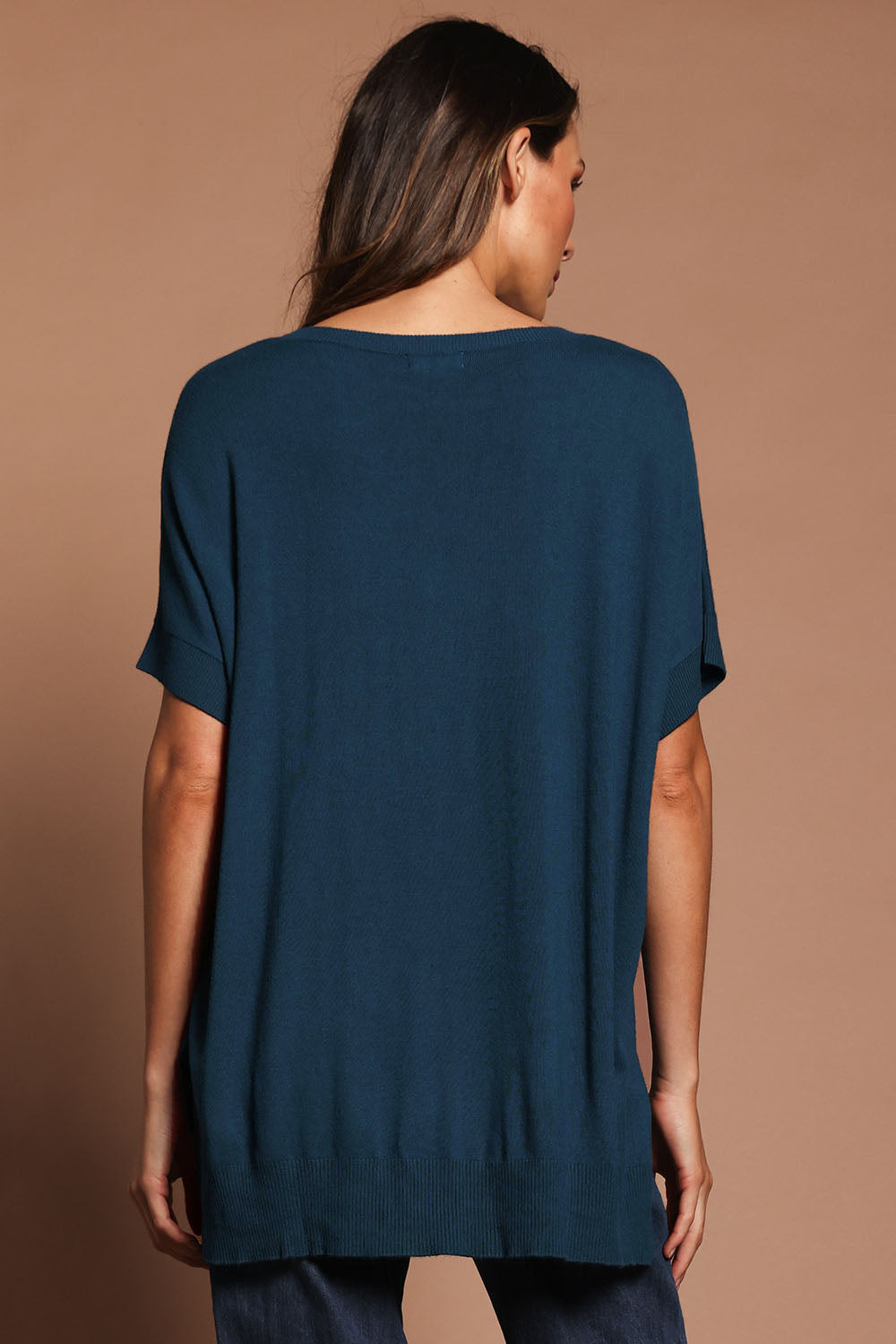 Model Madeline wearing size S of The All Season V Neck High Low Tee in colour Blueocean (Blue), from the back