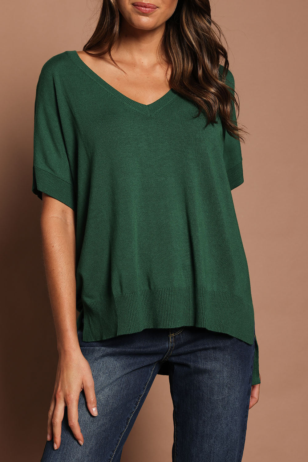 Model Madeline wearing size S of The All Season V Neck High Low Tee in colour Cactus (Green), from the front, cropped image