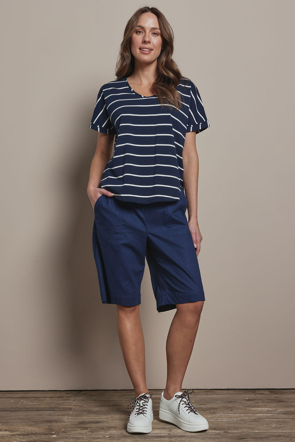 Model Madeline wearing size 10 of The Striped V Neck Tee in colour Navywhite (Blue), from the front, showing the whole outfit
