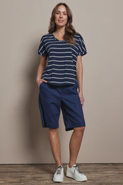 Model Madeline wearing size 10 of The Striped V Neck Tee in colour Navywhite (Blue), from the front, showing the whole outfit