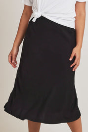 Model Terri-Leigh wearing size 14 of The Pull On Bias Skirt in colour Black (Black), from the front, cropped image