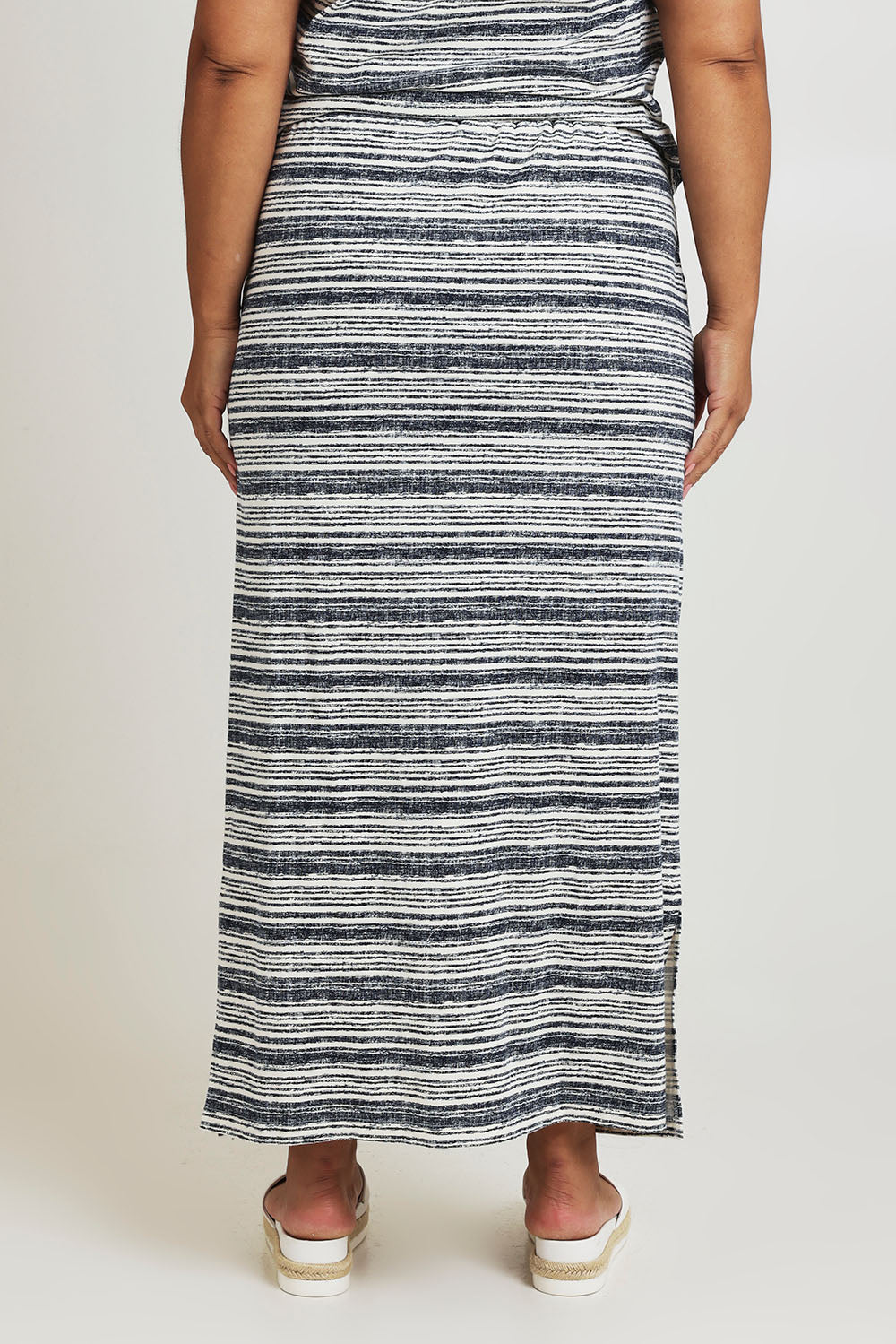Model Ashleigh wearing size 16 of The Striped Pull On Skirt in colour Navystripe (Blue), from the back