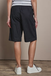 Model Madeline wearing size 10 of The Rib Waistband Short in colour Black (Black), from the back