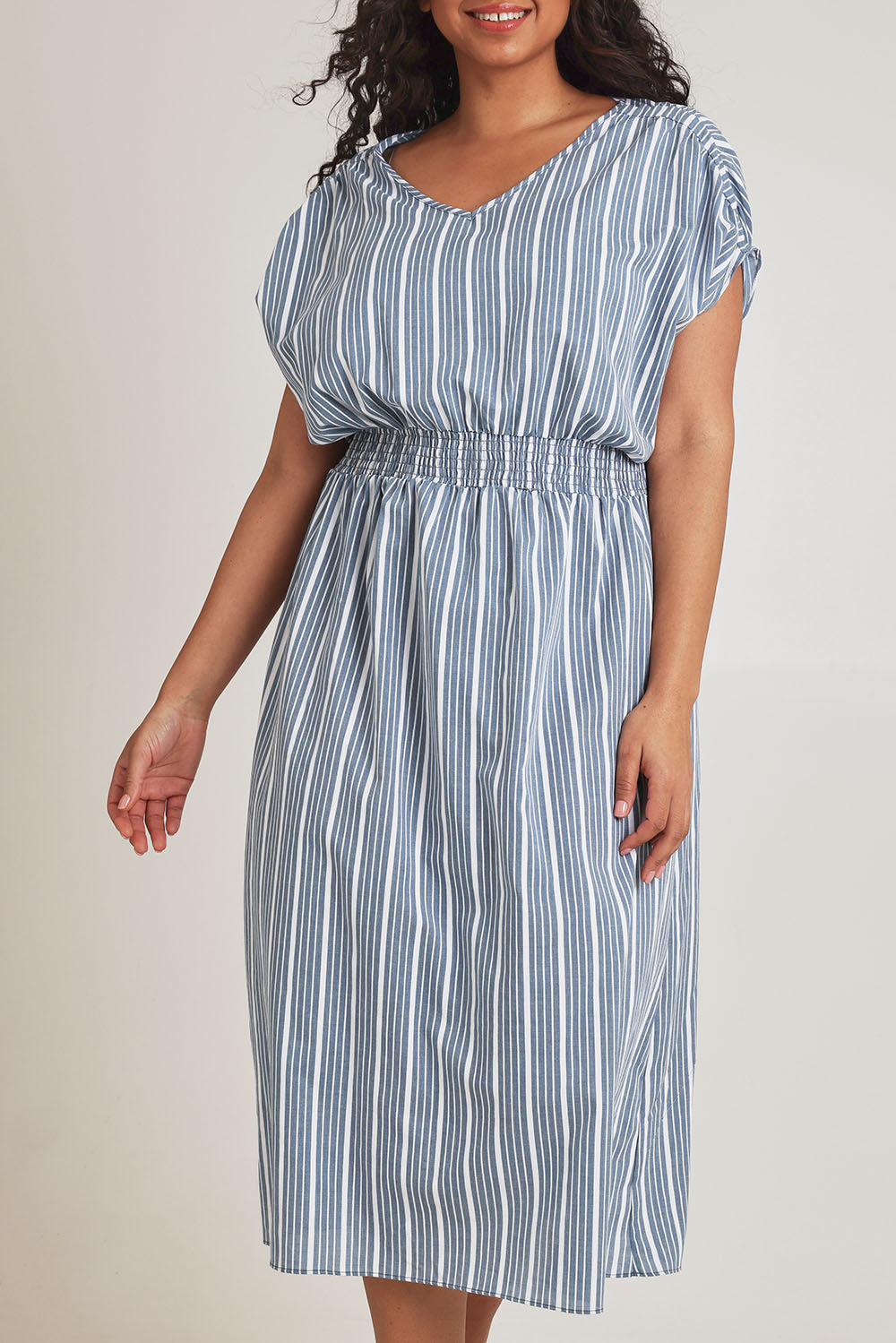 Model Terri-Leigh wearing size 14 of The Cotton Shirred Waist Dress in colour Denimblue (Blue), from the front, cropped image