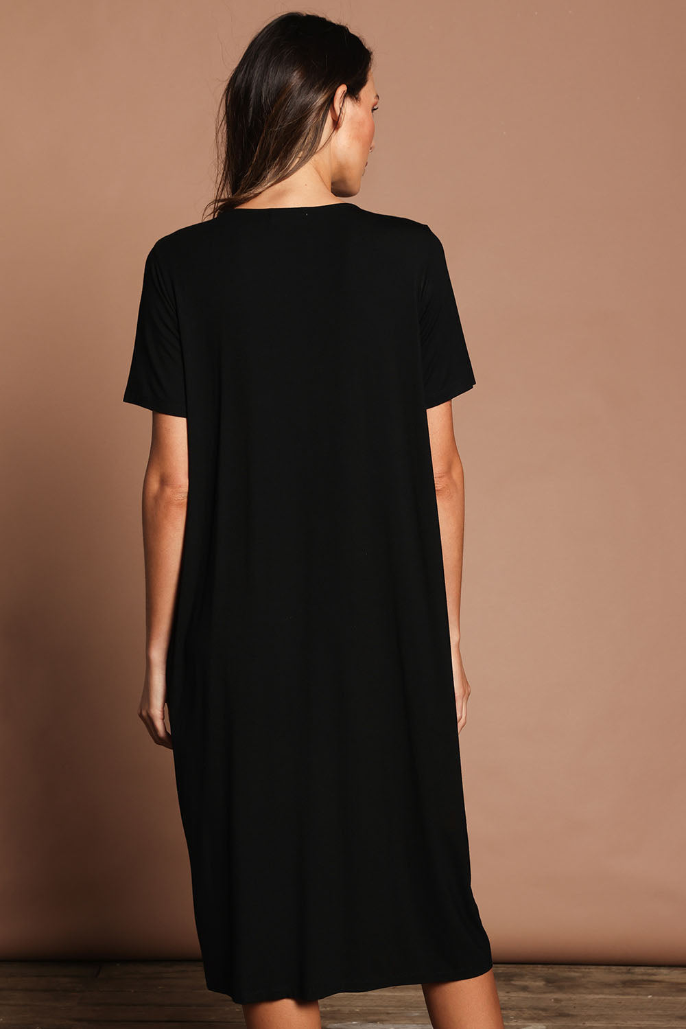 Model Madeline wearing size 10 of The Pack & Go Luxe Bamboo Button Up Dress with Pockets in colour Black (Black), from the back