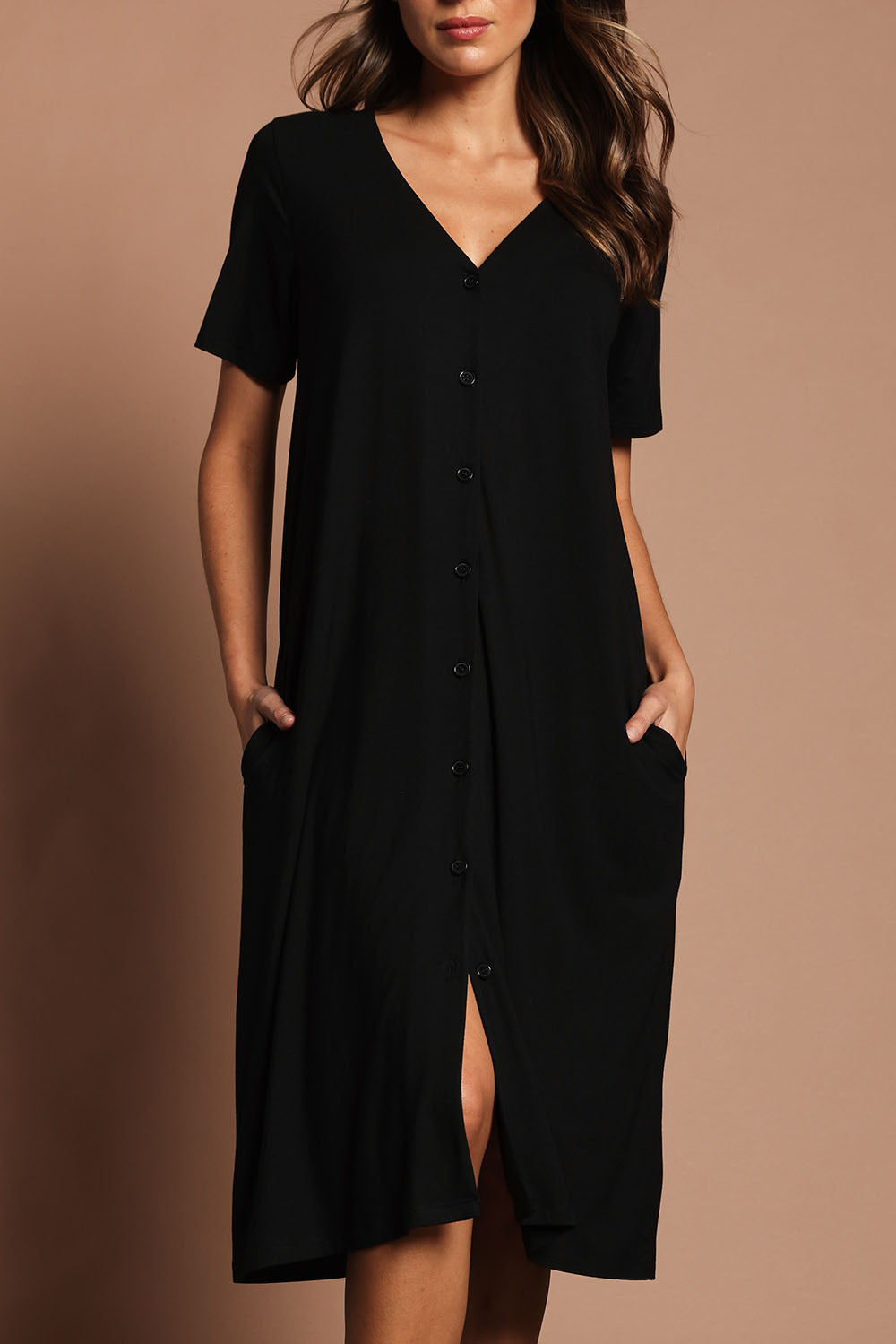 Model Madeline wearing size 10 of The Pack & Go Luxe Bamboo Button Up Dress with Pockets in colour Black (Black), from the front, cropped image