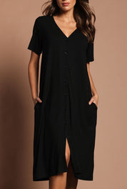 Model Madeline wearing size 10 of The Pack & Go Luxe Bamboo Button Up Dress with Pockets in colour Black (Black), from the front, cropped image