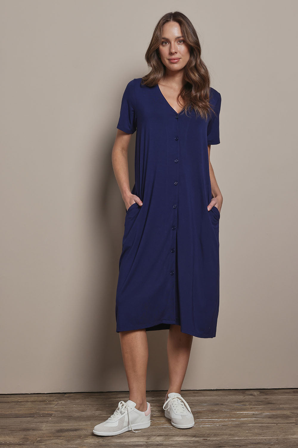 Model Madeline wearing size 10 of The Pack & Go Luxe Bamboo Button Up Dress with Pockets in colour Frenchnavy (Blue), from the front, showing the whole outfit