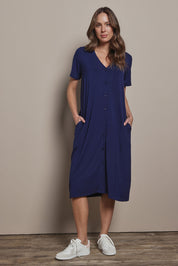 Model Madeline wearing size 10 of The Pack & Go Luxe Bamboo Button Up Dress with Pockets in colour Frenchnavy (Blue), from the front, showing the whole outfit