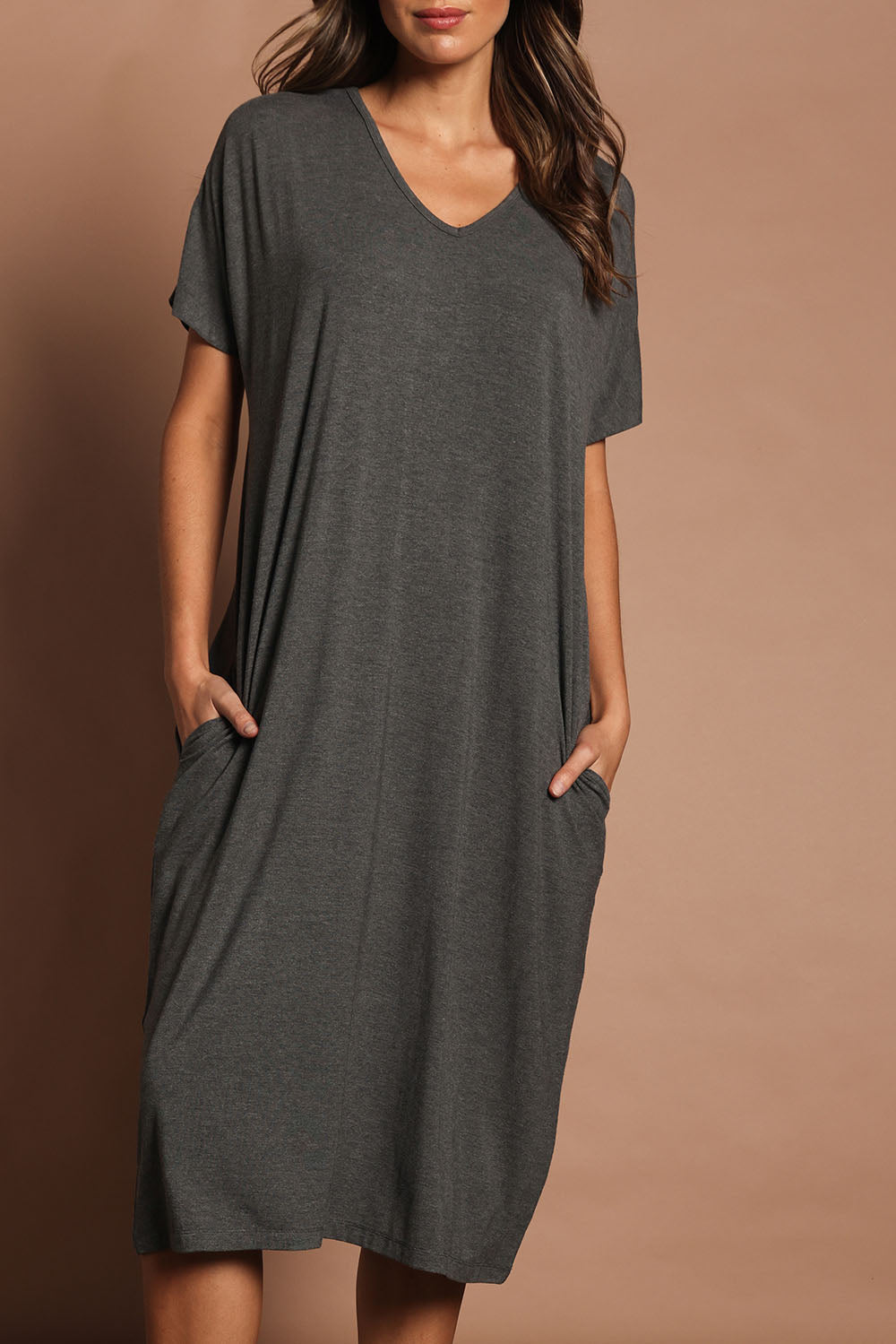 Model Madeline wearing size 10 of The Pack & Go Luxe Bamboo Pull On Dress with Pockets in colour Charcoal (Grey), from the front, cropped image