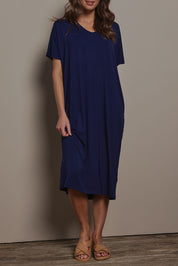 Model Madeline wearing size 10 of The Pack & Go Luxe Bamboo Pull On Dress with Pockets in colour Frenchnavy (Blue), from the front, cropped image