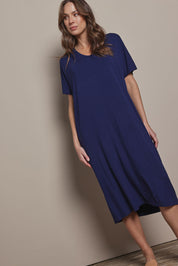 Model Madeline wearing size 10 of The Pack & Go Luxe Bamboo Pull On Dress with Pockets in colour Frenchnavy (Blue), from the front, cropped image