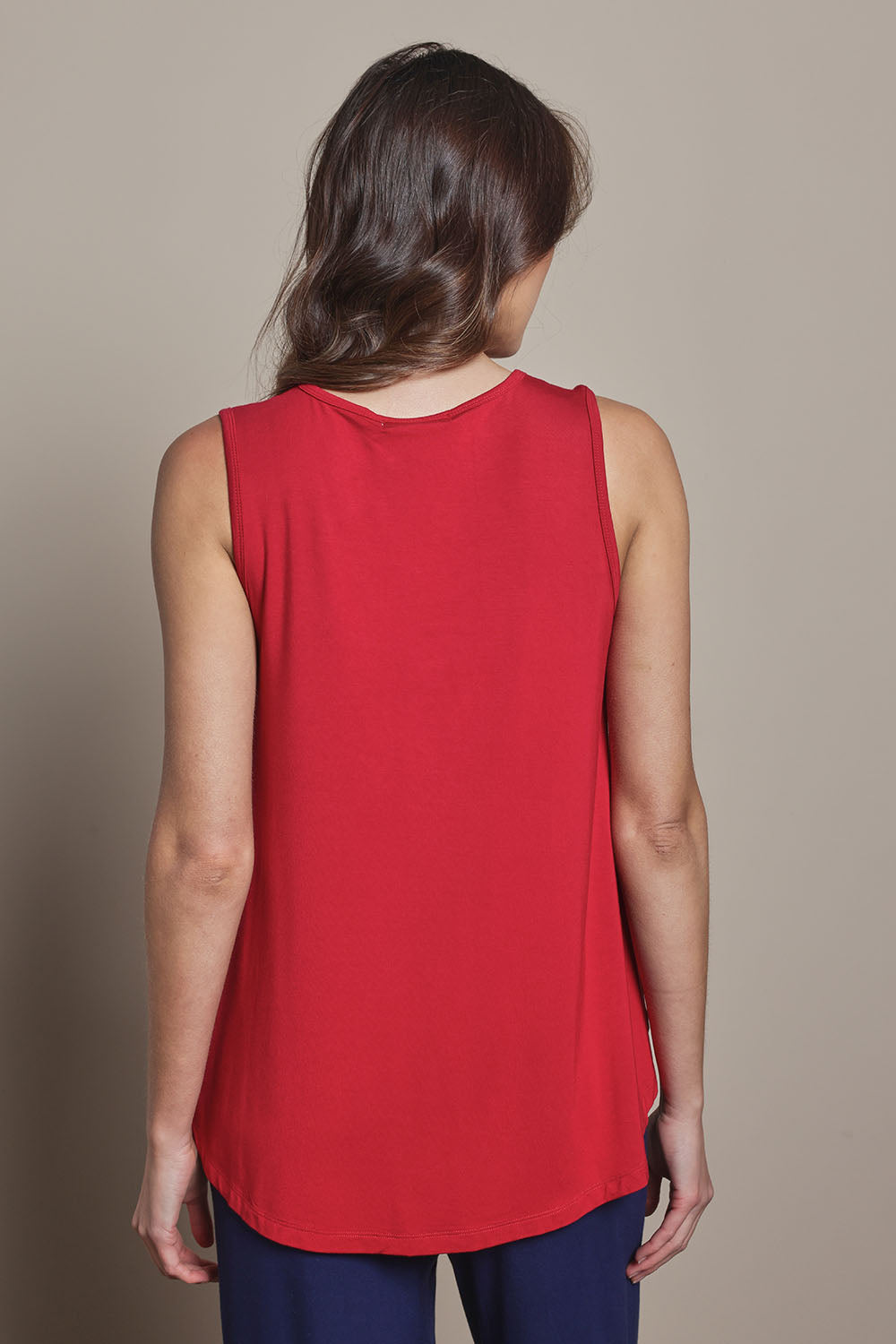 Model Madeline wearing size 10 of The Pack & Go Luxe Bamboo Swing Tank in colour Cherryred (Red), from the back