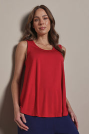 Model Madeline wearing size 10 of The Pack & Go Luxe Bamboo Swing Tank in colour Cherryred (Red), from the front, cropped image