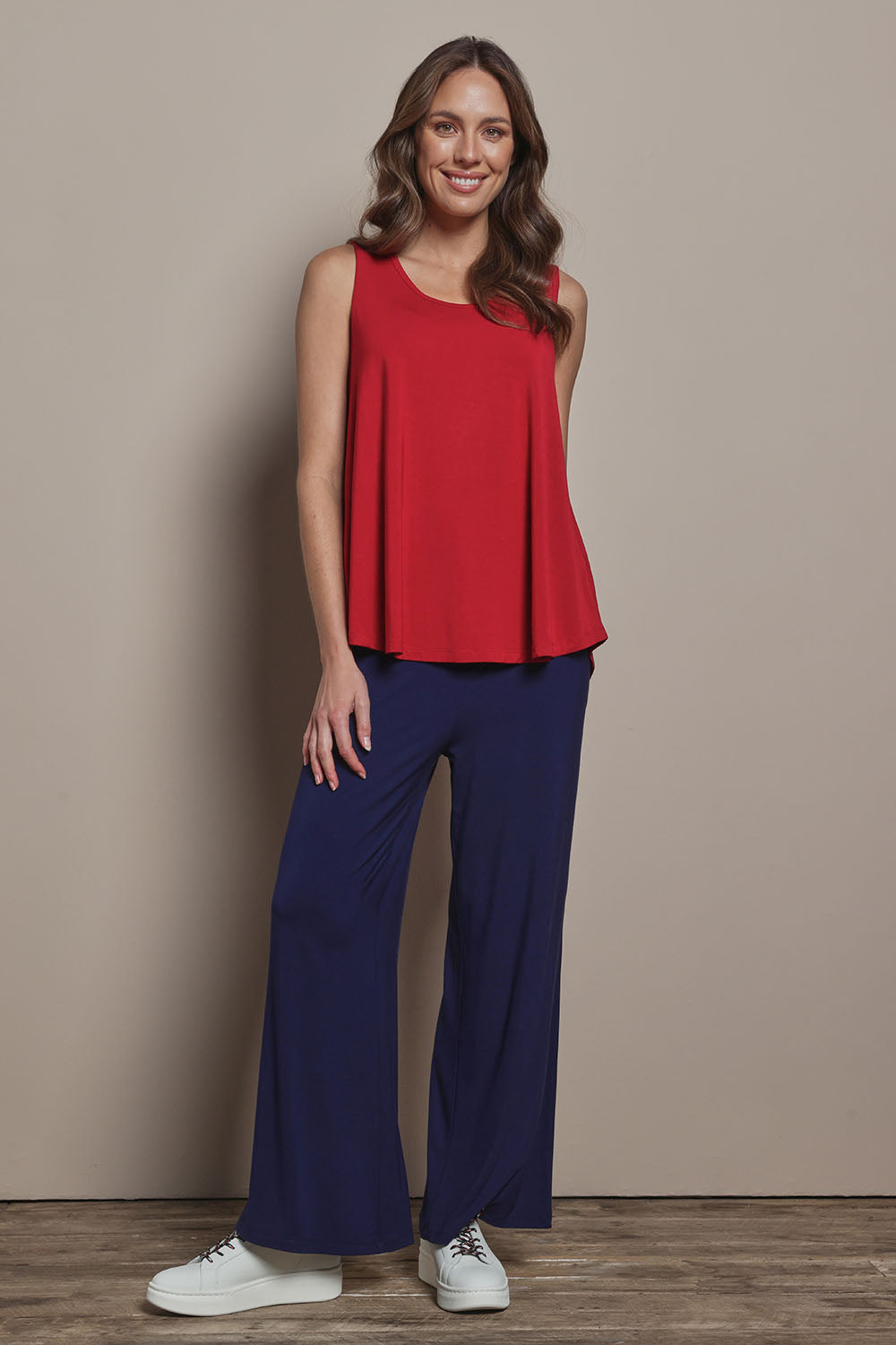 Model Madeline wearing size 10 of The Pack & Go Luxe Bamboo Swing Tank in colour Cherryred (Red), from the front, showing the whole outfit