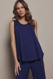 Model Madeline wearing size 10 of The Pack & Go Luxe Bamboo Swing Tank in colour Frenchnavy (Blue), from the front, cropped image