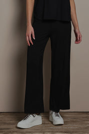 Model Madeline wearing size 10 of The Pack & Go Luxe Bamboo Wide Leg Pant in colour Black (Black), from the front, cropped image