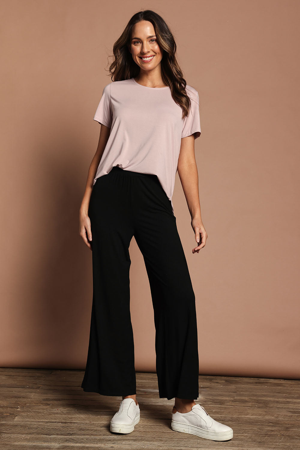 Model Madeline wearing size 10 of The Pack & Go Luxe Bamboo Wide Leg Pant in colour Black (Black), from the front, showing the whole outfit