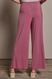 Model Amanda wearing size 10 of The Pack & Go Luxe Bamboo Wide Leg Pant in colour Smokeyrose (Pink), from the back
