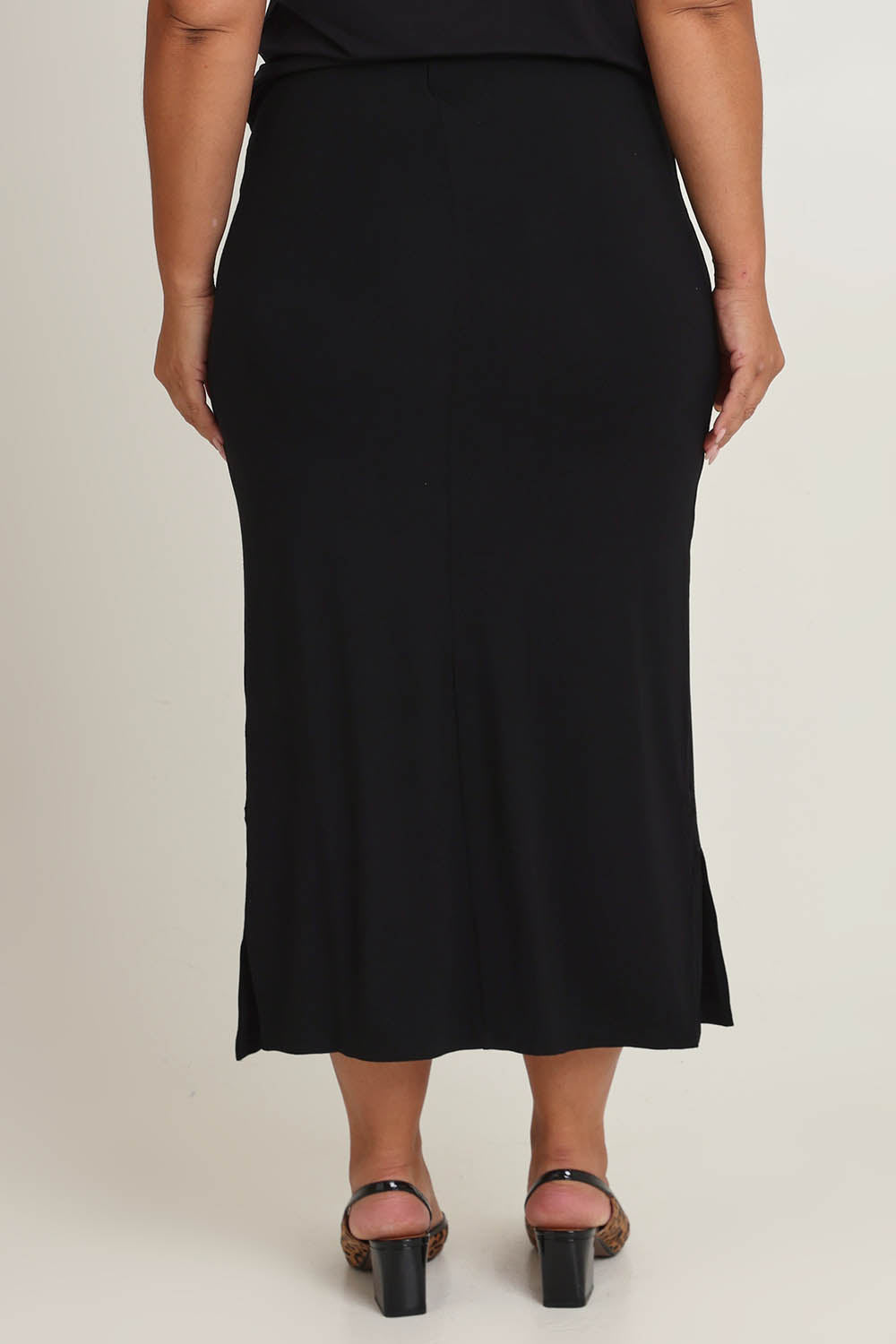 Model Ashleigh wearing size 16 of The Pack & Go Luxe Bamboo Pull On Maxi Skirt in colour Black (Black), from the back
