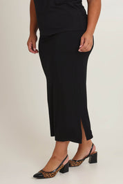 Model Ashleigh wearing size 16 of The Pack & Go Luxe Bamboo Pull On Maxi Skirt in colour Black (Black), from the front, cropped image