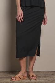 Model Madeline wearing size 10 of The Pack & Go Luxe Bamboo Pull On Maxi Skirt in colour Black (Black), from the front, cropped image